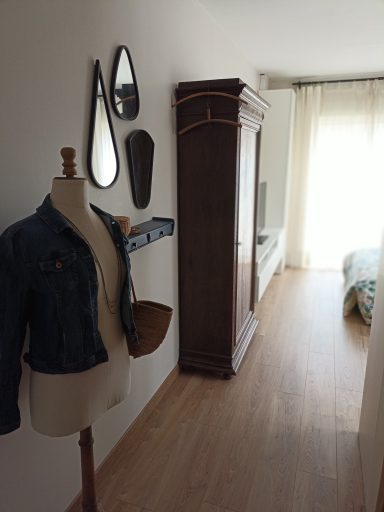 Un ancien bustier accessoirisé et une accumulation de miroirs surmontant une tablette relookée invitent à rejoindre la chambre lumineuse.
